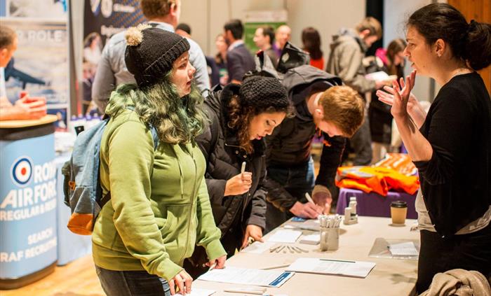 Delegates getting information from an information stand at an exhibition.